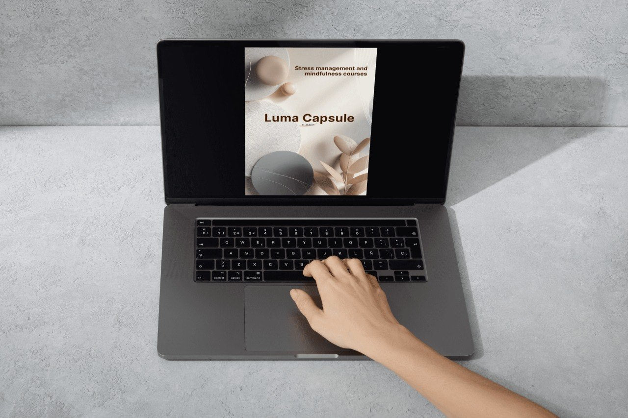 Person using a laptop with 'Luma Capsule' displayed on the screen on a gray surface.