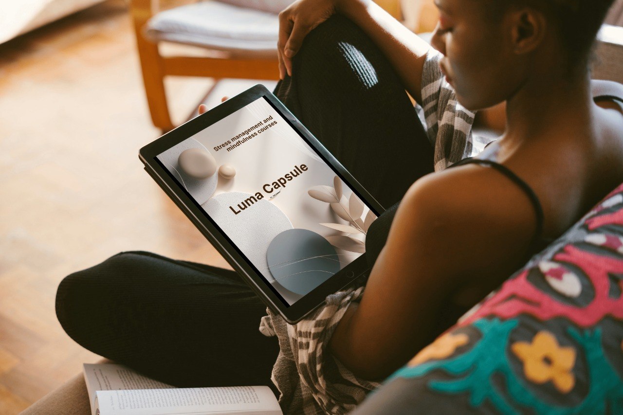 Person holding a tablet with 'Luma Capsule' displayed, sitting on a couch.