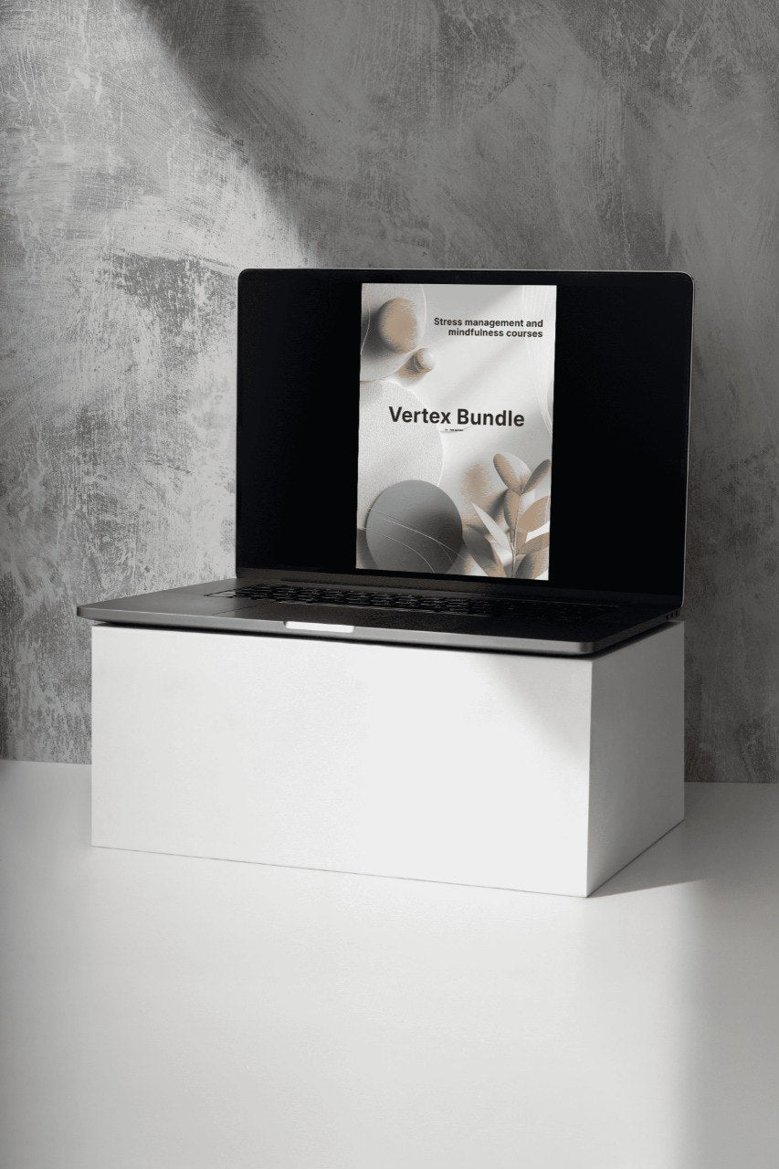 Laptop with a screen displaying 'Vertex Bundle' on a white surface with a gray textured wall background.